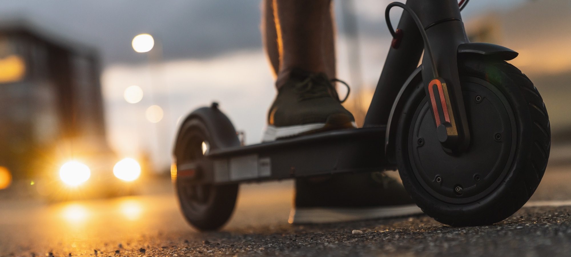 Young man at night with electric scooter or e-scooter in the city, Electric urban transportation concept image